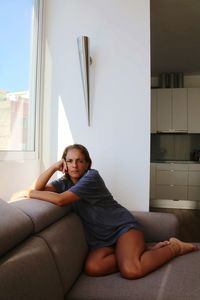 Young woman lying on sofa at home