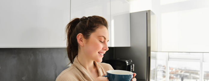 Young woman drinking coffee at home