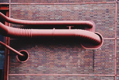 Red pipes on brick wall