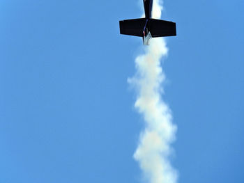 Low angle view of airplane flying against blue sky