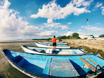 Rear view of man standing on sea against sky