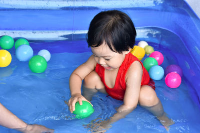 High angle view of boy playing with toys in pool