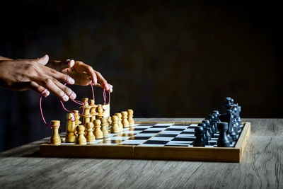 Man playing with chess against black background