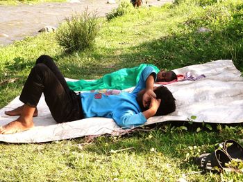 Full length of young woman sleeping in park