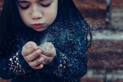 Close-up of girl blowing glitter