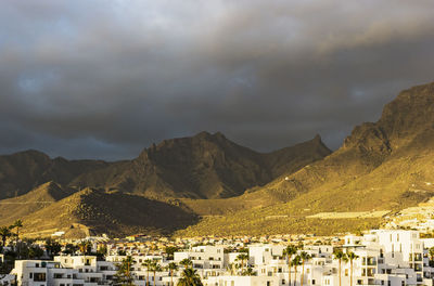 Townscape by mountains against sky