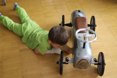 High angle view of boy playing on hardwood floor at home