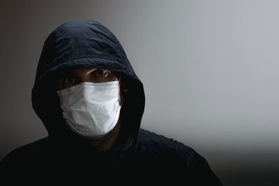 Portrait of man wearing mask against white background