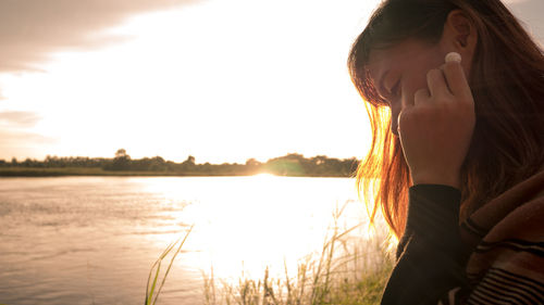 Portrait of woman standing in lake against sky