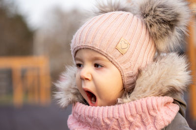 Portrait of little girl yawning woman in warm clothing