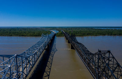 Bridges over river against clear blue sky