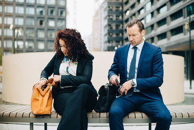 Young couple sitting in front of office building