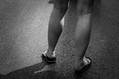 Low section of woman standing on road