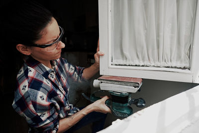 A young girl using a sander. concept of female empowerment