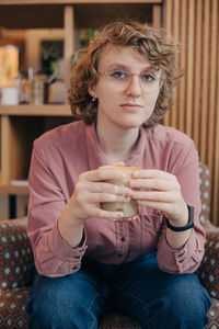 Portrait of young woman sitting at home