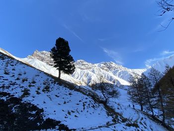 Scenic view of snowcapped mountains against blue sky