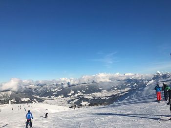 People on snow covered mountain against sky