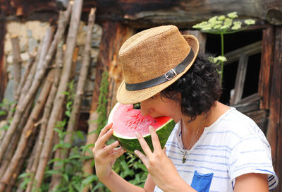 Midsection of woman holding hat