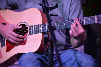 Midsection of man playing guitar