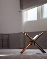 Close-up of wooden table against wall at home