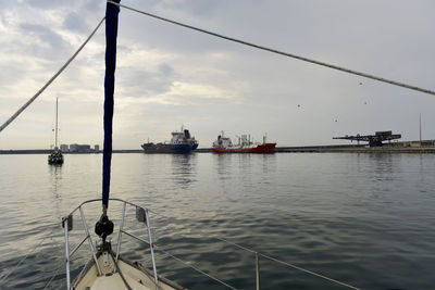 Sailboats sailing in sea against sky