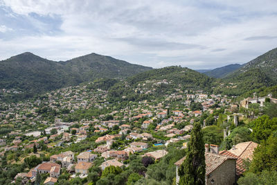 Aerial view of townscape and mountains against sky