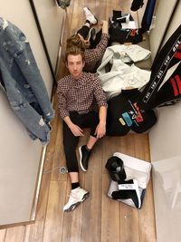 Full length portrait of young man sitting on floor