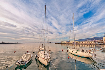 Boats moored in sea against sky