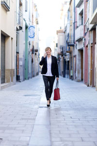 Portrait of woman walking on street in city