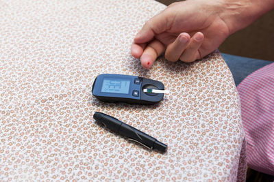 Close-up of person holding smart phone on table