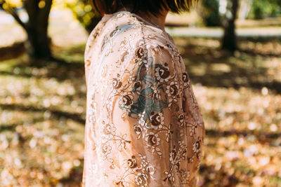 Midsection of mid adult woman standing at park during autumn