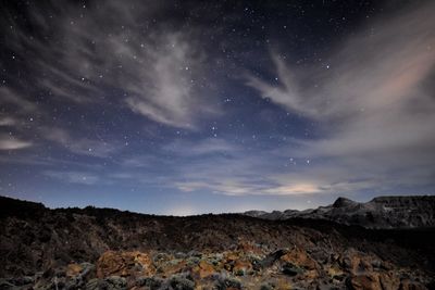 Scenic view of mountains against sky at night