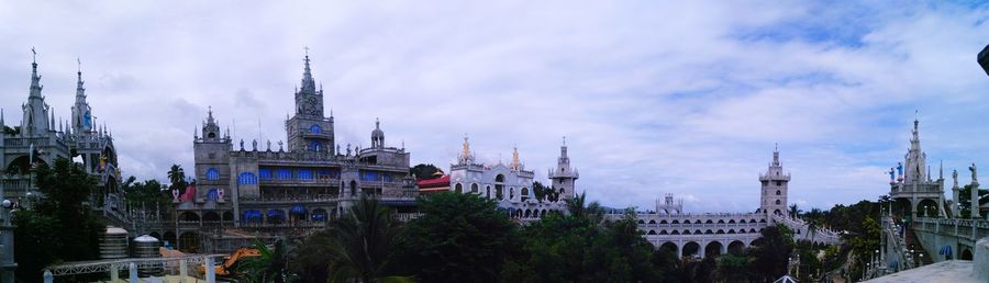 View of cityscape against cloudy sky