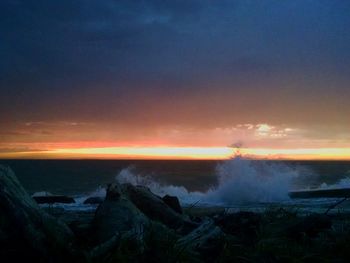 Scenic view of sea against dramatic sky at sunset