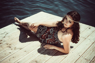 Portrait of young woman sitting on hardwood floor