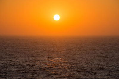 Scenic view of sea against orange sky