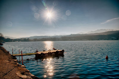 Ducks swimming in lake against sky