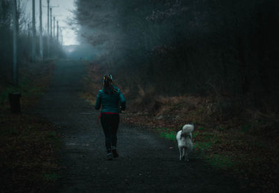 Rear view of dog running in forest