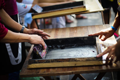 Cropped image of people screen printing at workshop