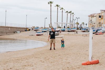 Father and child walking along the beach