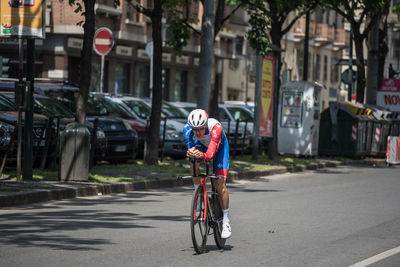 Man riding bicycle on road in city