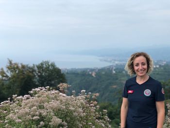 Portrait of smiling woman standing against sky