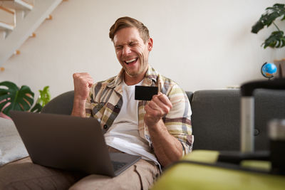 Young woman using phone while sitting at home