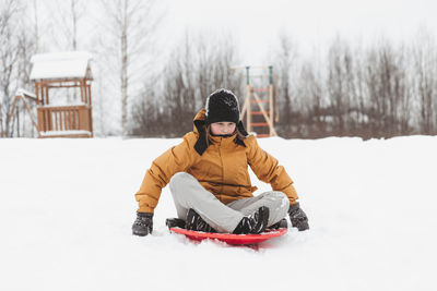 A girl rides down a slide in a winter park, a healthy lifestyle, a sports walk