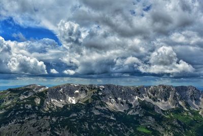 Scenic view of mountains against cloudy sky