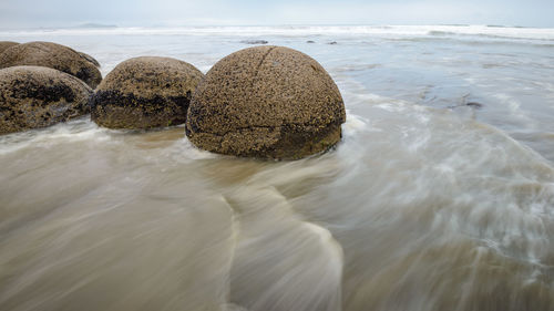 Rocks in sea against sky