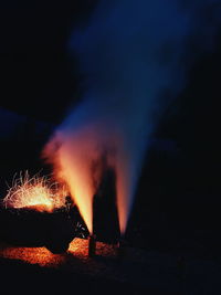 Close-up of illuminated lighting equipment against sky at night