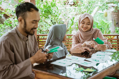 Portrait of senior man using mobile phone while sitting on table