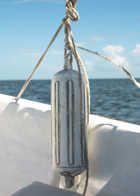 Close-up of rope tied on boat against sea