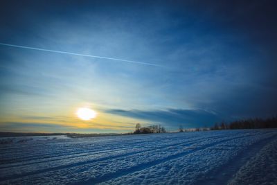 Scenic view of snow covered landscape against blue sky